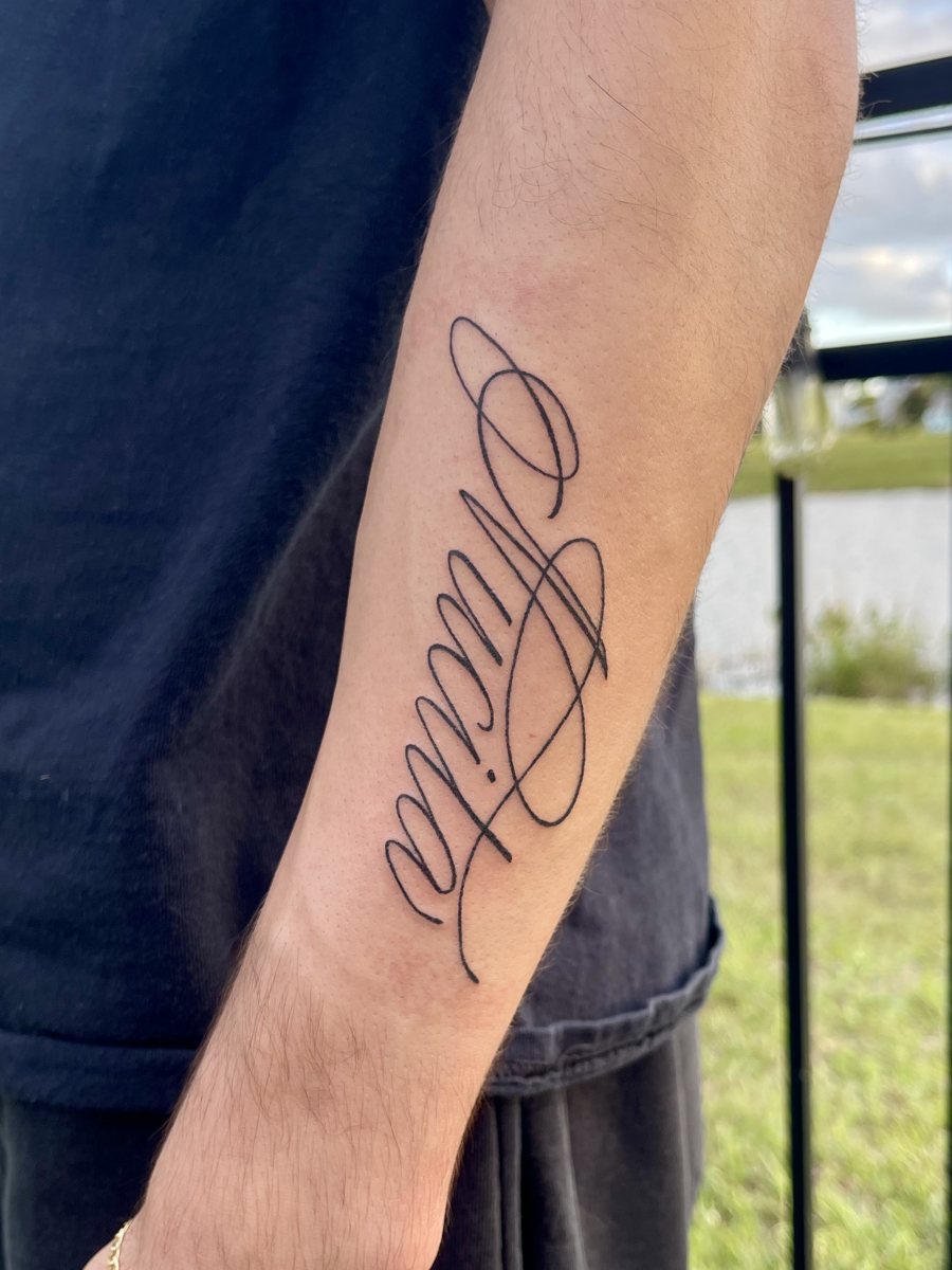 Custom script lettering hand poke tattoo along a forearm, Puerto Rico