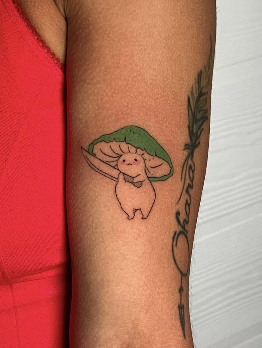 Kawaii mushroom with a sword hand poke tattoo on an upper arm, Puerto Rico