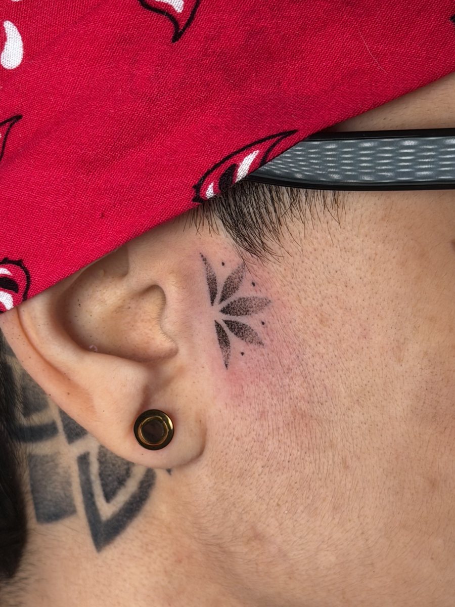 Micro dotwork flower hand poke face tattoo beside the ear, San Juan
