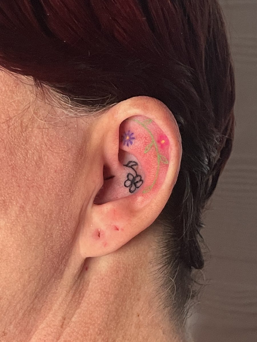 Tiny colored flowers hand poke tattoo inside the ear, Puerto Rico